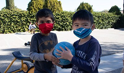 TuitionDropdown Little Boys with masks playing ball