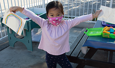 Little girl with mask and her artwork